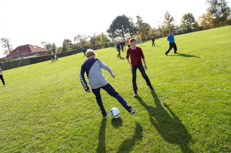 Børn spiller fodbold på plæne ved Bavnehøj Skole