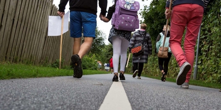 Barn følges med voksne på vej til skole