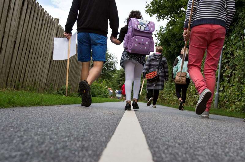 Barn følges med voksne på vej til skole